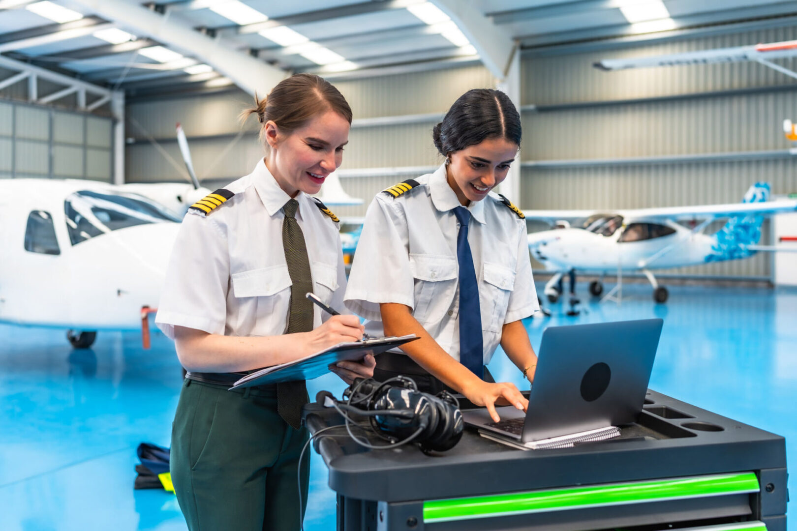 Female pilots preparing for flight in hangar
