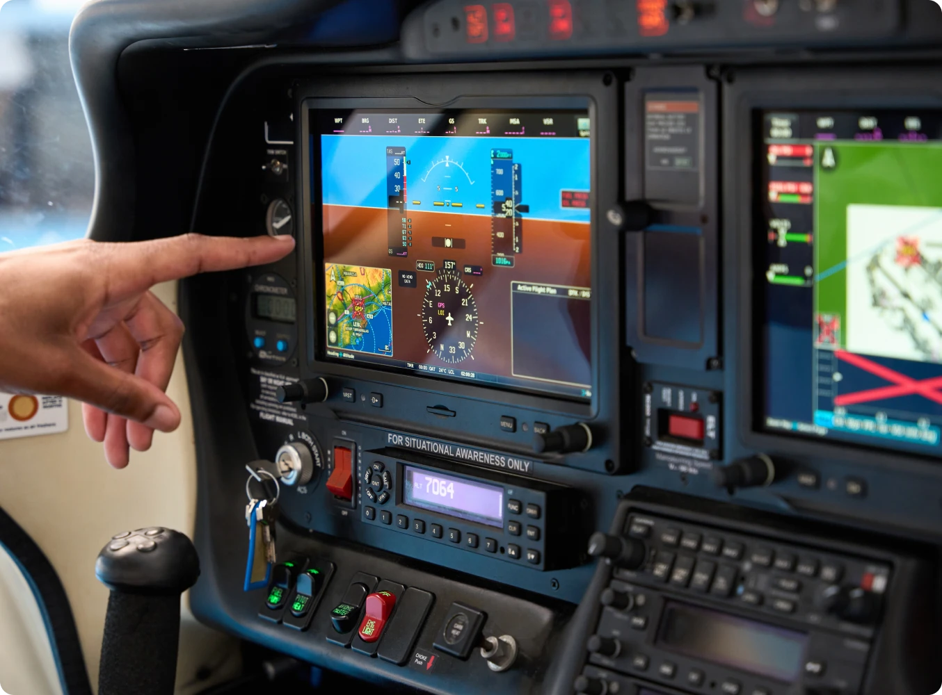 Hand pointing at airplane control panel